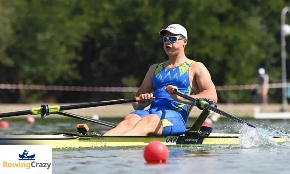 A single male sculler in a blue suit 