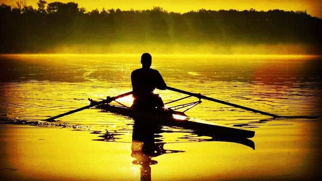 silhouette of a rower sculling alone 