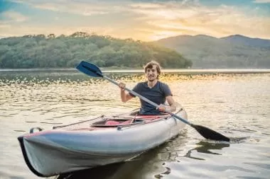 a man paddling alone in his kayak