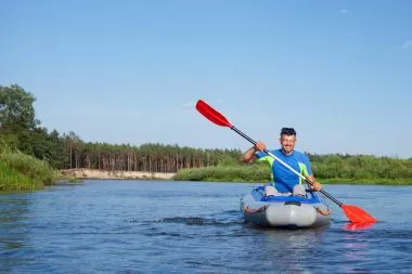 A man happily kayaking alone