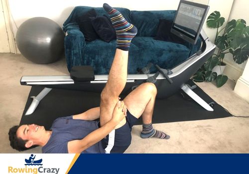 Max Secunda performs hamstring stretches with his Hydrow rowing machine in the background