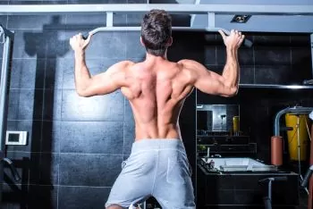 Young Man Training Pull Ups in a Gym