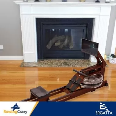 The Ergatta water rower set up near a fireplace