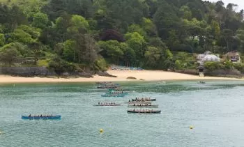 several rowing boats near the coast of a white sand beach