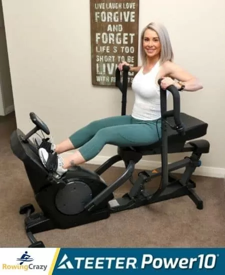 a woman holding the handlebars of a TEETER POWER10 elliptical rower and preparing to start a workout