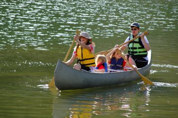 family canoeing at a lake