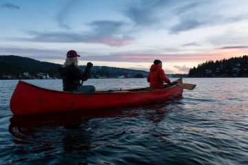 friends paddling a wooden canoe