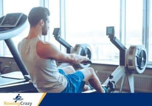 man in white shirt and blue shorts using concept 2 rower