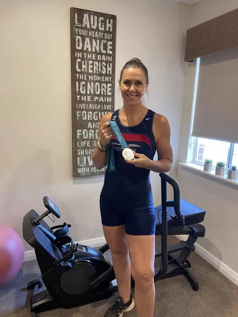 Rachel Taylor holding her Olympic Rowing Silver medal