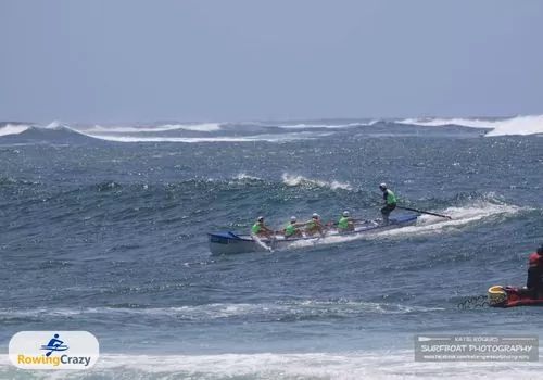 a surf boat rowing team training on rough open waters